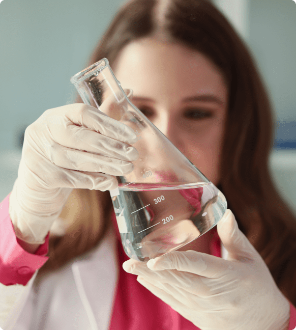 Scientist examining liquid in a laboratory flask.
