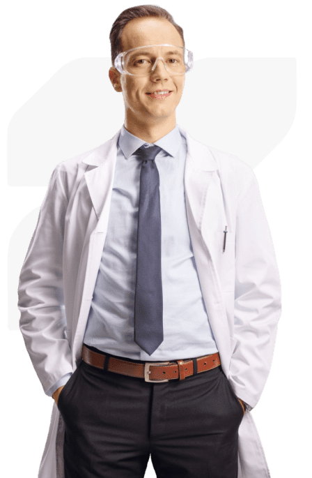 Smiling person in lab coat and goggles.